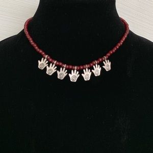 Custom. Silver hands w/ maroon beaded necklace.